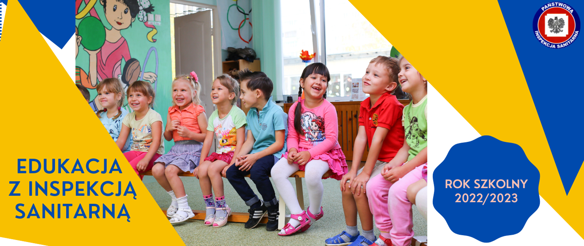 Dzieci w wieku wczesnoszkolnym, siedzące na ławce w sali szkolnej