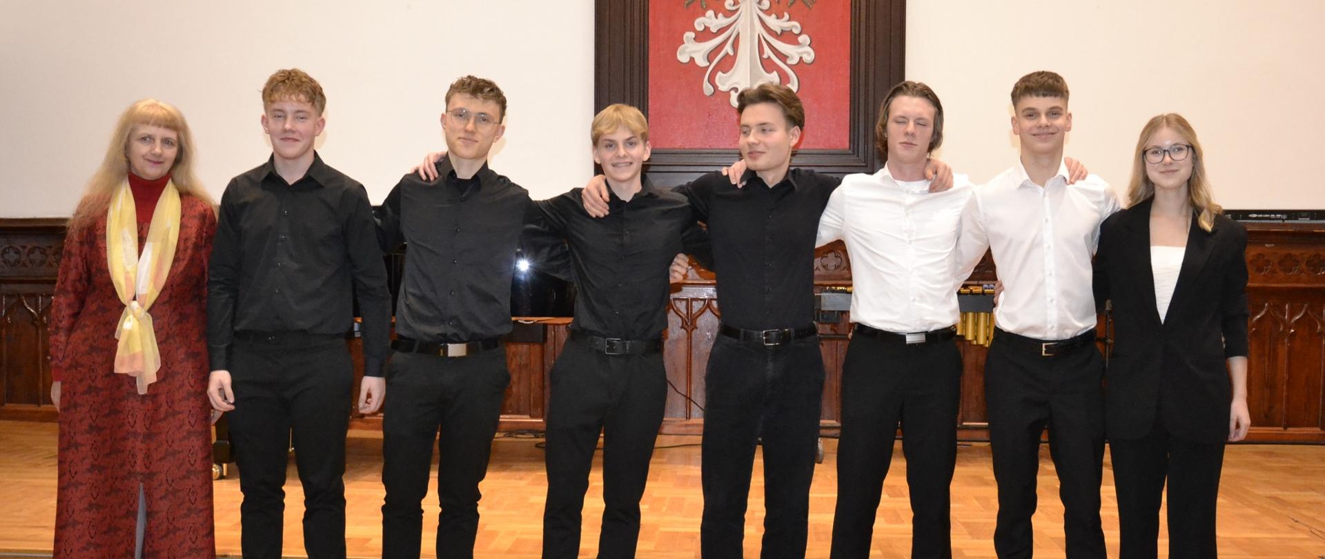 Grupa uczniów klasy V PSM II stopnia oraz nauczycielka stoją na scenie Sali Królewskiej po koncercie klasowym, który odbył się 11 lutego 2026 roku.