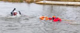 Strażak przygotowuje się do podjęcia osoby poszkodowanej z wody, używając koła ratunkowego