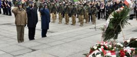 Na zdjęciu Komendant Centralnej Szkoły PSP w towarzystwie oficera Policji oraz Straży Granicznej salutują stojąc przed pomnikiem Piłsudskiego. W tle uczestnicy uroczystości