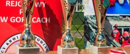 Na zdjęciu widoczne puchary dla najlepszych trzech drużyn uczestniczących w XXXIII Spartakiadzie HDK PCK w Brunarach. W tle rollupy promujące ruch czerwonokrzyski.
