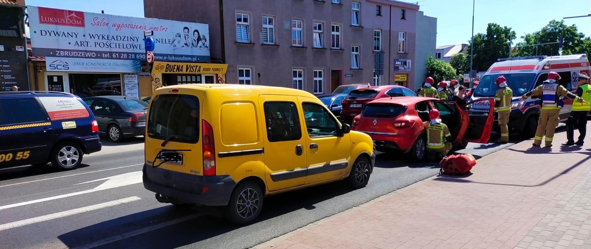 Na zdjęciu pojazd z wypadku strażacy prowadzący czynności ZRM i Policjant