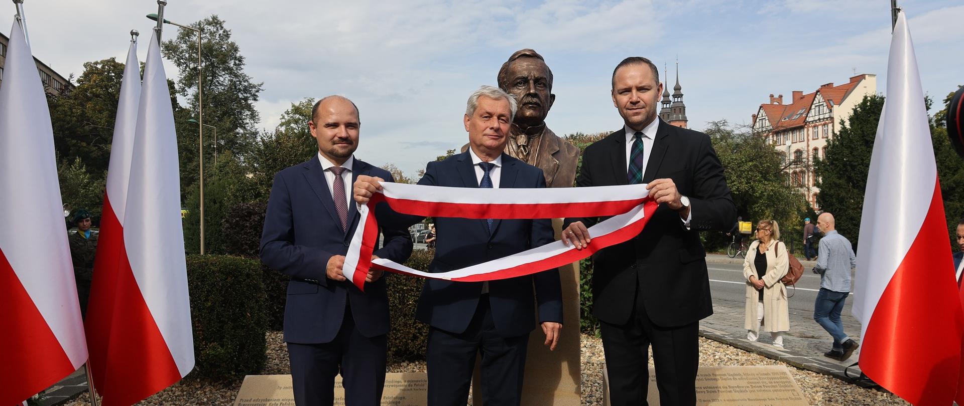 Wojewoda Opolski Sławomir Kłosowski wraz z dr Karolem Nawrockim Prezesem Instytutu Pamięci Narodowej i dr Kamilem Dworaczkiem Dyrektorem Oddziału Instytutu Pamięci Narodowej we Wrocławiu odsłaniają pomnik Wojciecha Korfantego na placu przed budynkiem Opolskiego Urzędu Wojewódzkiego.