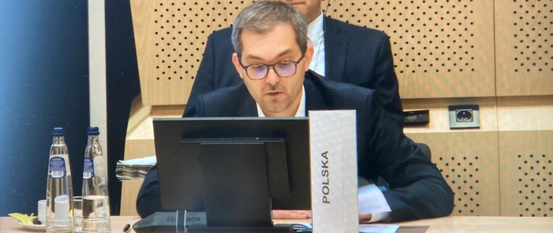 Deputy Minister Marek Niedużak behind a computer screen
