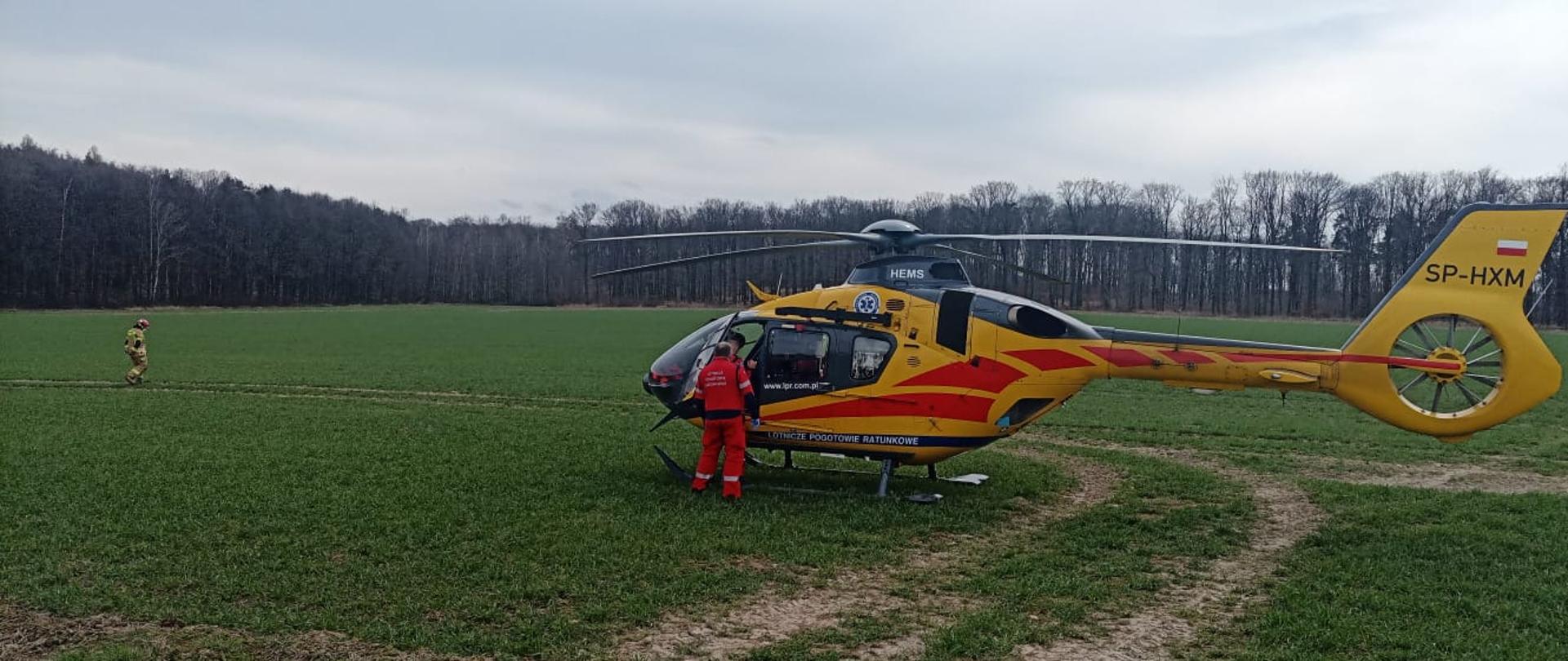 Ratownik medyczny stojący na tle smigłowca LPR