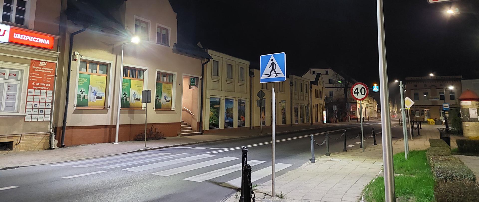 Przejście dla pieszych w ścisłej zabudowie mieszkalnej - kamienice. Zamontowane dodatkowe lampy doświetlające przejście, wyraźnie zwiększona widoczność w obrębie przejścia.