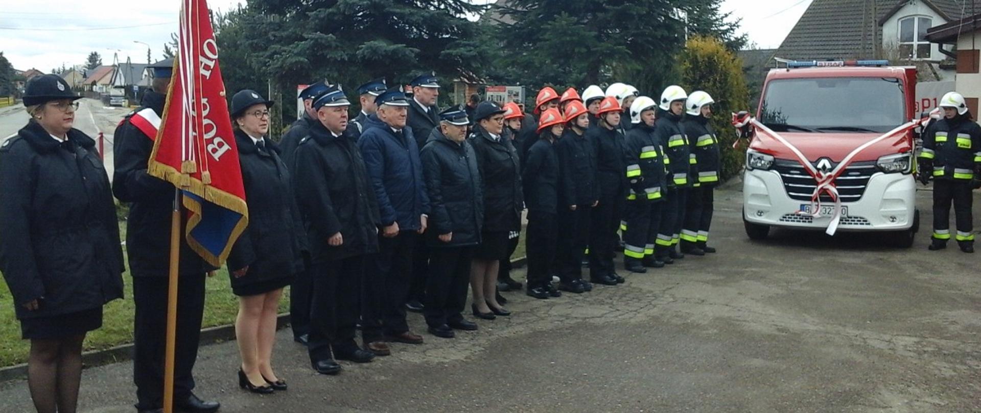 Na zdjęciu widać druhów z OSP Borkowo wraz ze sztandarem, którzy stoją obok nowo przekazanego samochodu pożarniczego.