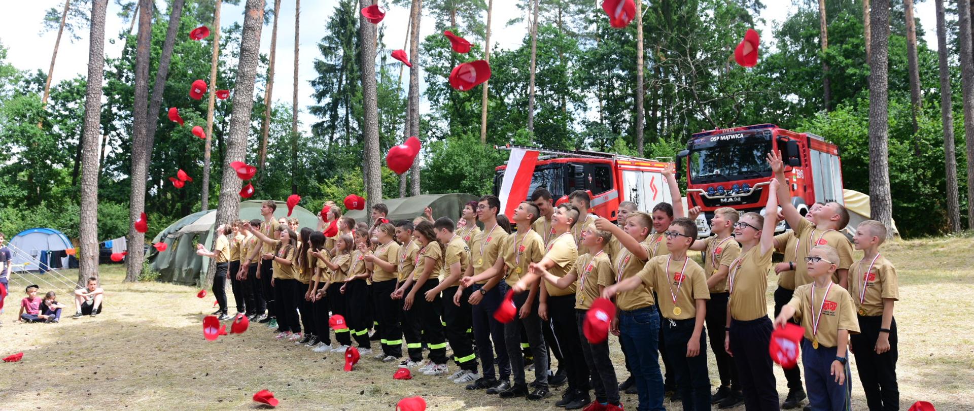 młodzi adepci pożarnictwa podczas rzucania czapek