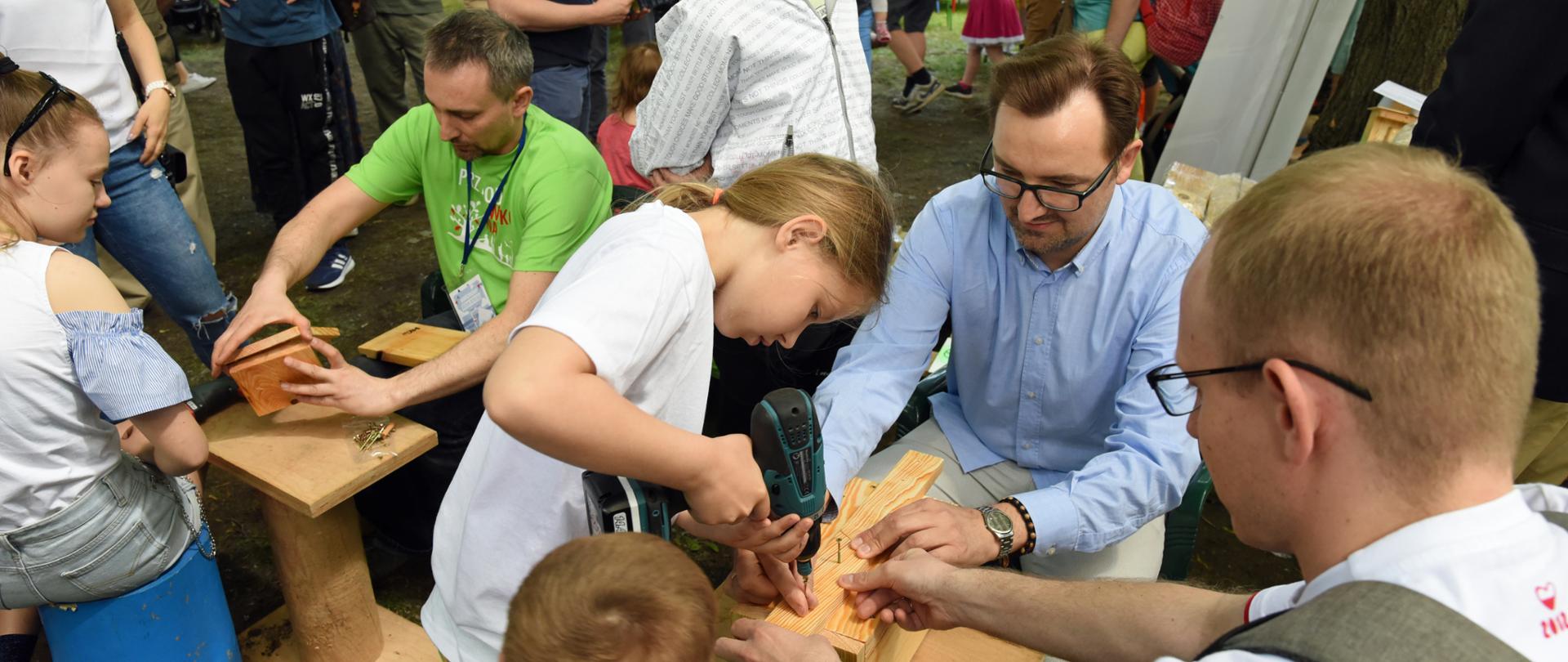 wiceminister Sławomir Mazurek buduje wraz z dziećmi budkę lęgową dla ptaków
