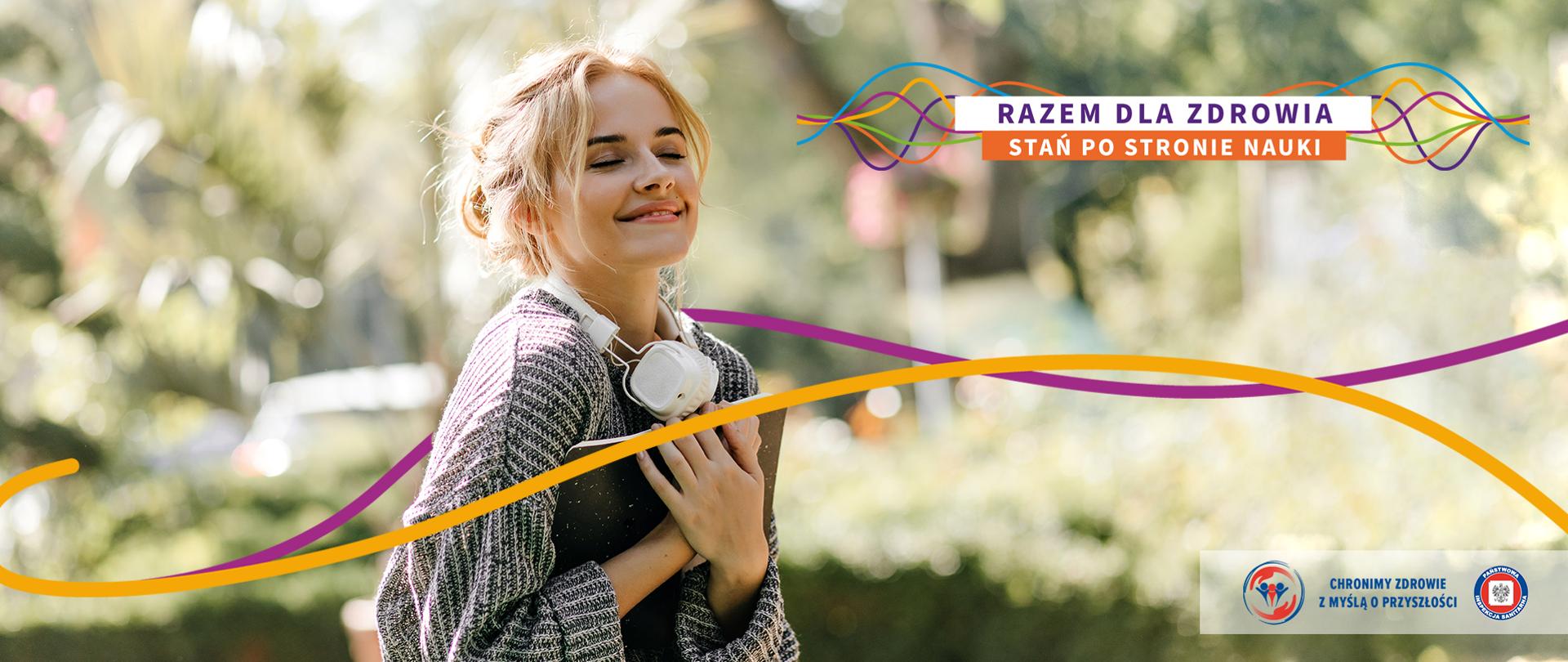 Uśmiechnięta dziewczyna, która w ręku trzyma notatnik. Wokół niej szarfy: fioletowa i pomarańczowa. W prawym górnym rogu logo i hasło tegorocznego Światowego Dnia Zdrowia: "Razem dla zdrowia. Stań po stronie nauki" (tł. własne). W prawym dolnym rogu logo Państwowej Inspekcji Sanitarnej z hasłem: Chronimy zdrowie z myślą o przyszłości. 