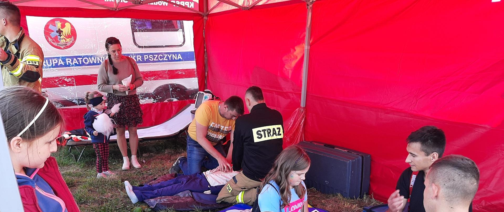 Na zdjęciu strażacy PSP uczą na manekinach pierwszej pomocy