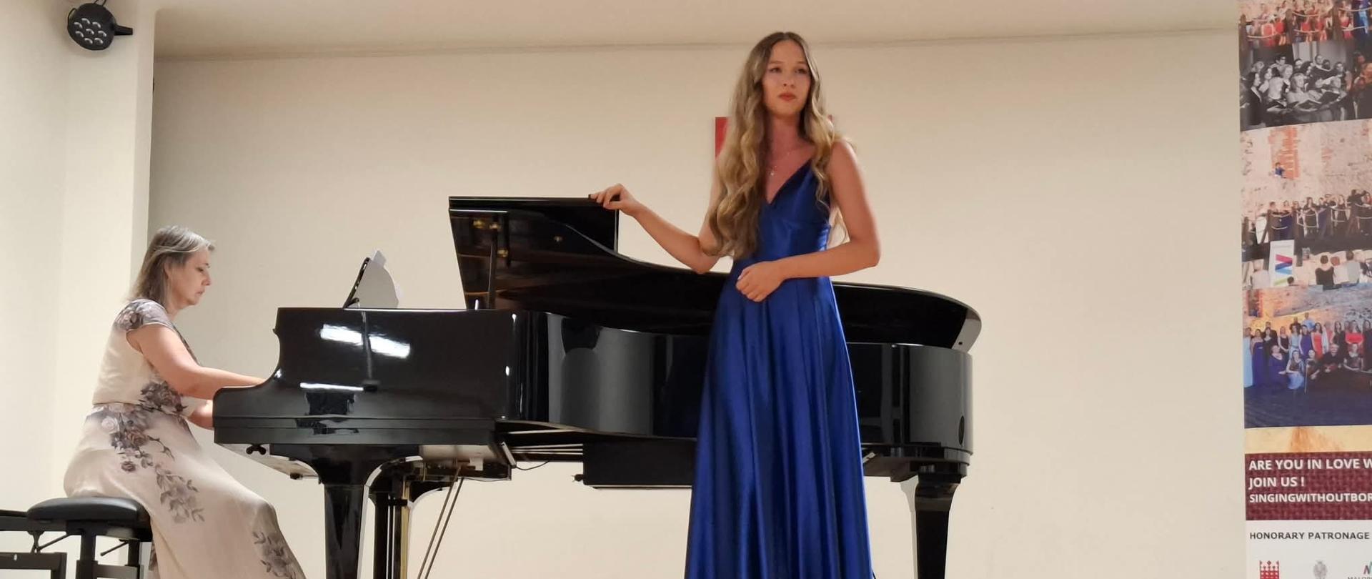 Amelia Szmidt na scenie w niebieskiej sukience