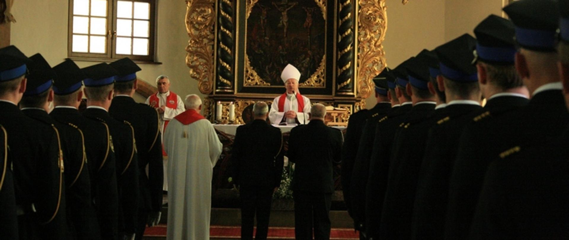 Zdjęcie przedstawia strażaków w mundurach galowych w kościele podczas mszy