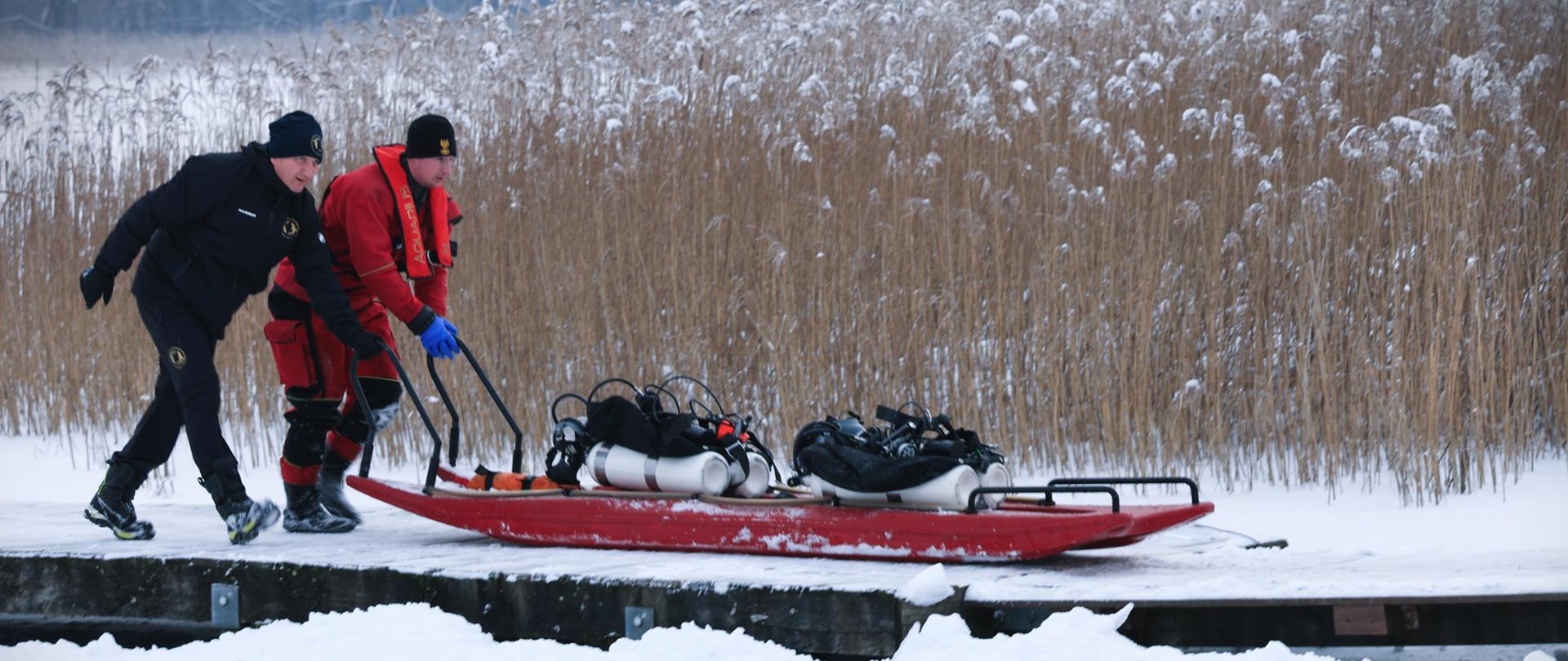 Ćwiczenia pododdziałów Centralnego Odwodu Operacyjnego KSRG – ćwiczenia zgrywające Specjalistycznych Grup Ratownictwa Wodno – Nurkowego oraz Specjalistycznych Grup Sonarowych, pod kryptonimem „WINTERFEL 2026”. - strazacy z saniami lodowymi na pomoscie na zamarzniętym jeziorze