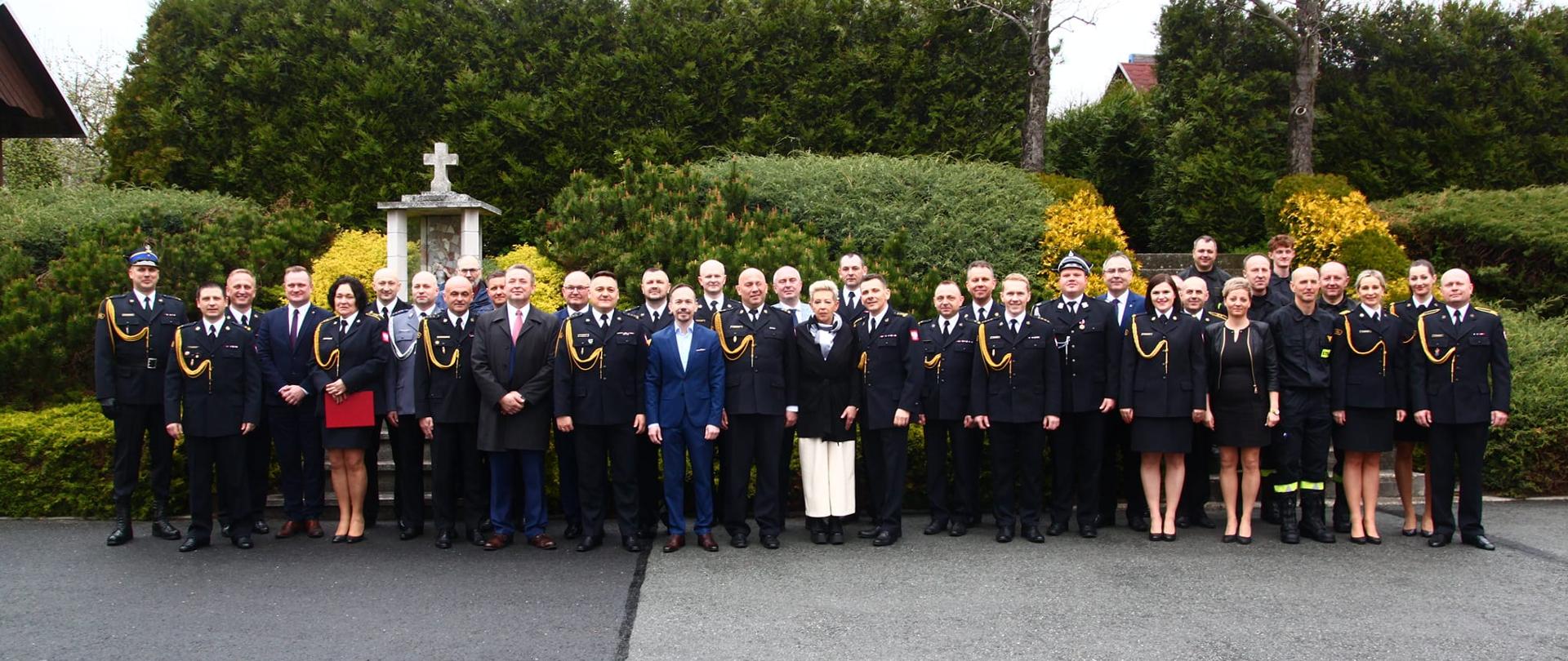 Wspólne zdjęcie wszystkich uczestników uroczystości powołania Komendanta Powiatowego PSP w Krapkowicach. Zdjęcie wykonano na placu Komendy Powiatowej PSP w Krapkowicach.