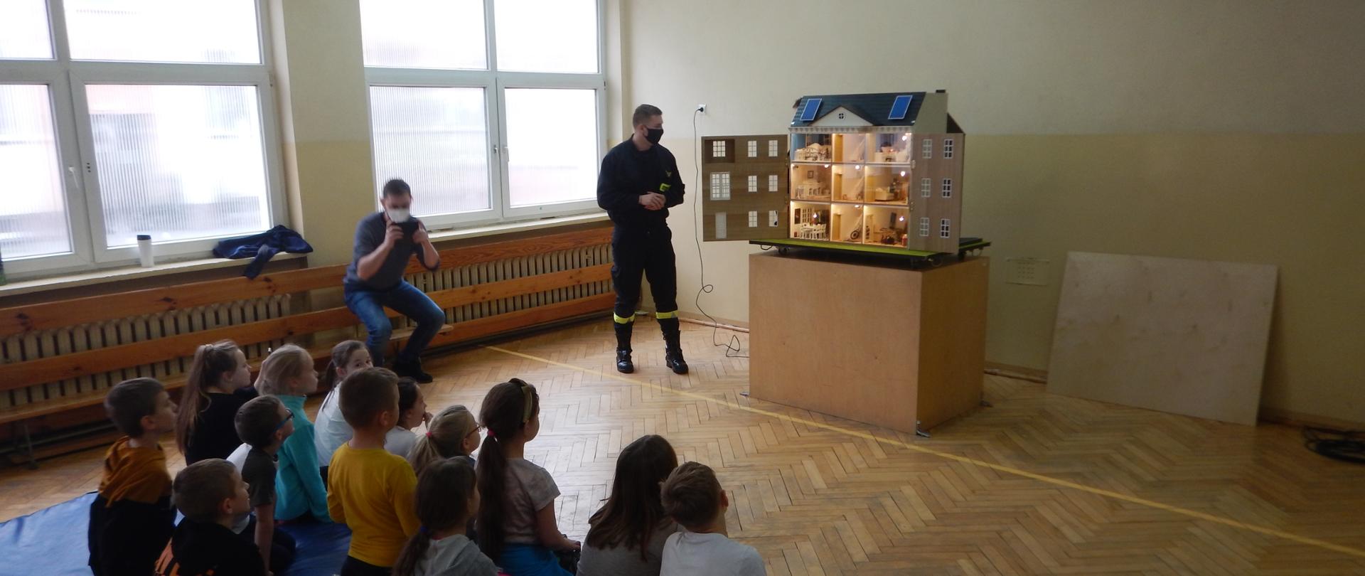 Zdjęcie przedstawia strażaka prezentującego symulator zagrożeń.