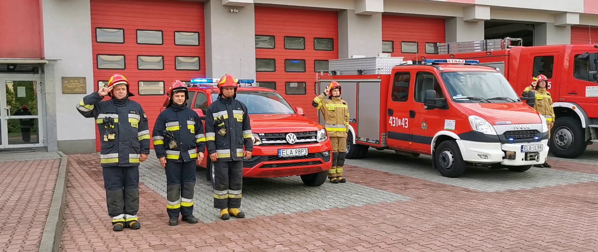 Zdjęcie przedstawia strażaków oddających honory w związku z 77 rocznicą Powstania Warszawskiego.
