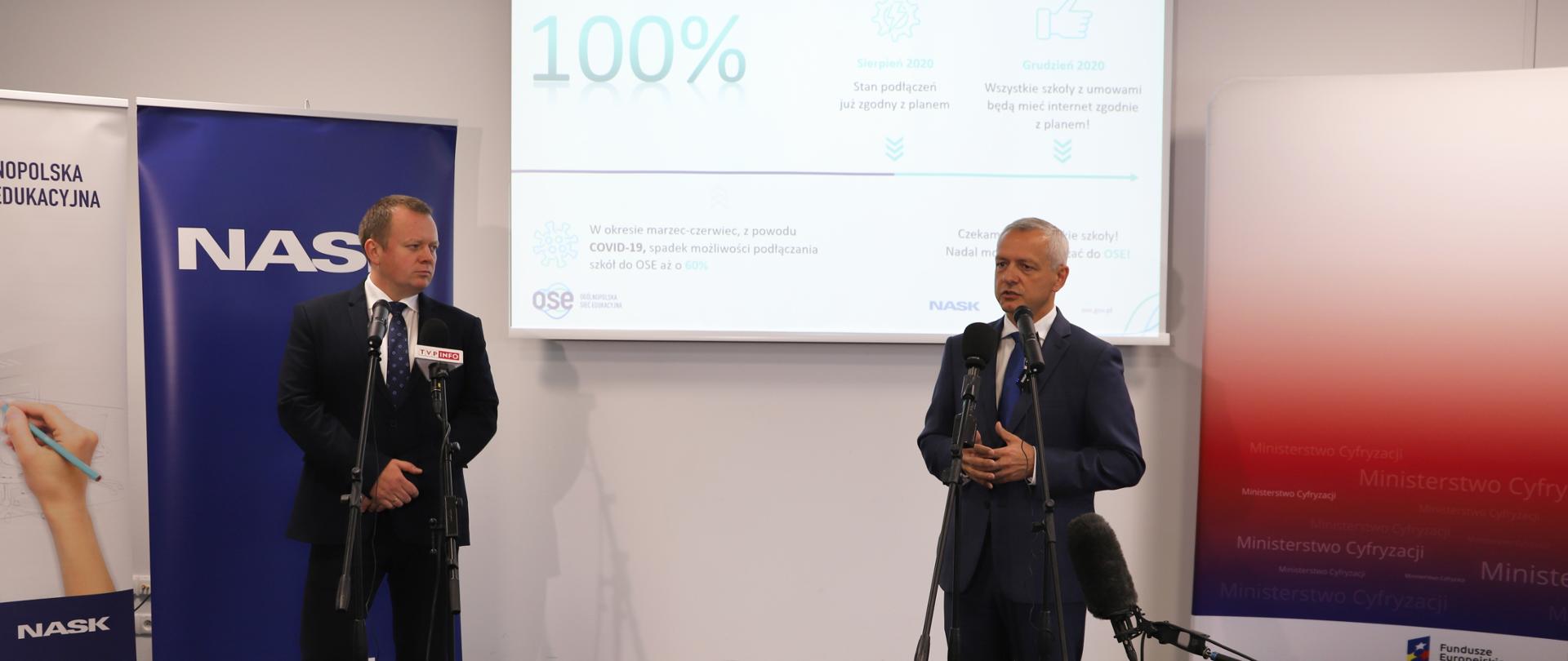 Minister cyfryzacji Marek Zagórski i dyrektor NASK Kamil Sitarski podczas konferencji prasowej, stoją przed mikrofonami.