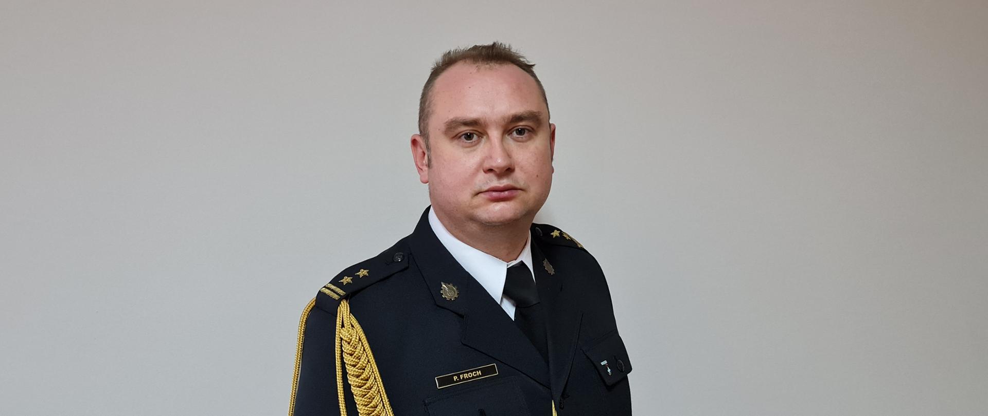 Zdjęcie Zastępcy Komendanta Miejskiego Państwowej Straży Pożarnej w Częstochowie w mundurze galowym na szarym tle