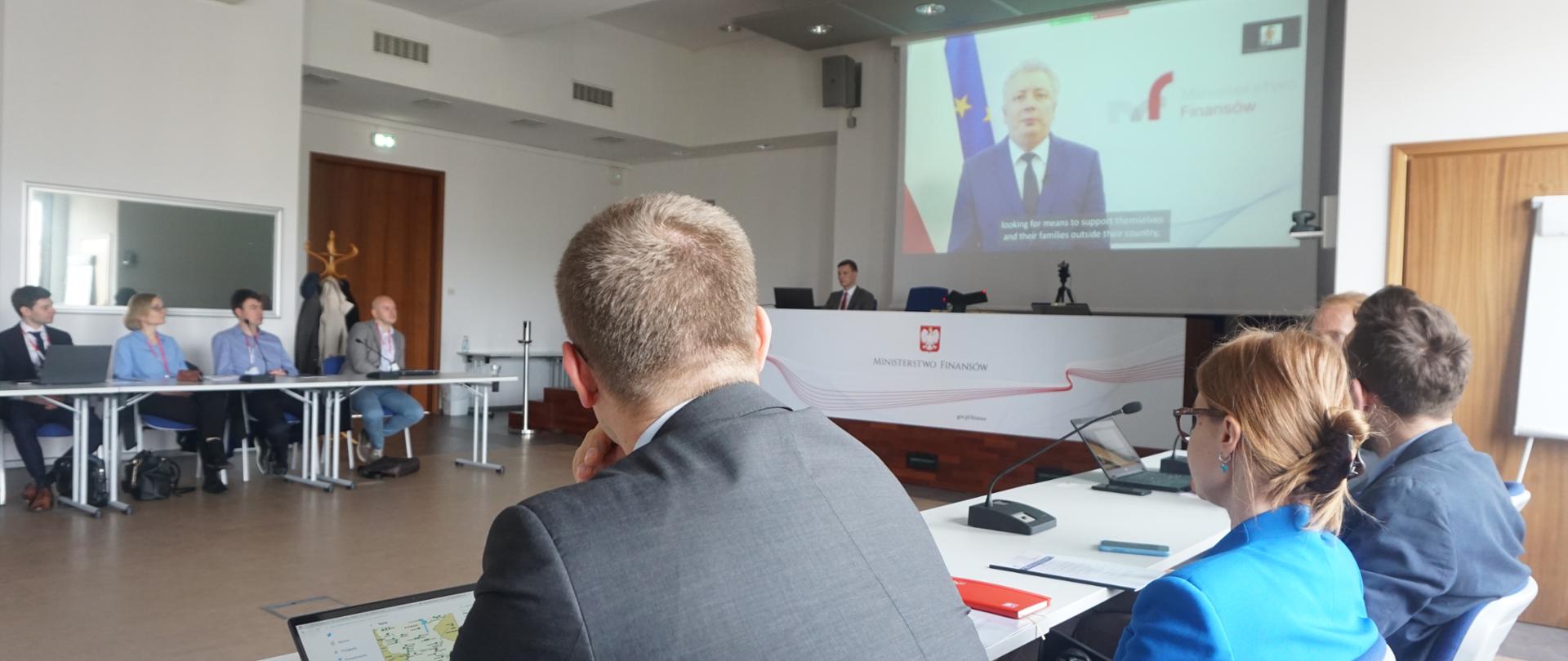 Uczestnicy spotkania na temat przemytu ludzi, współczesnego niewolnictwa i prania pieniędzy sali konferencyjnej słuchają wystąpienia ministra Sebastiana Skuzy