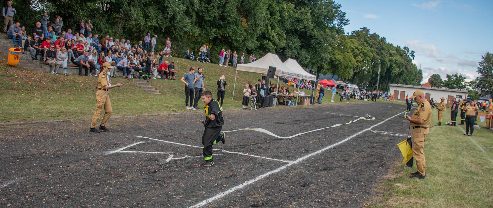 XIII ZAWODY SPORTOWO-POŻARNICZE DLA JEDNOSTEK OCHOTNICZYCH STRAŻY POŻARNYCH POWIATU KROTOSZYŃSKIEGO NA ZDJĘCIU WIDAĆ STRAŻAKÓW PODCZAS SĘDZIOWANIA ZMAGAŃ