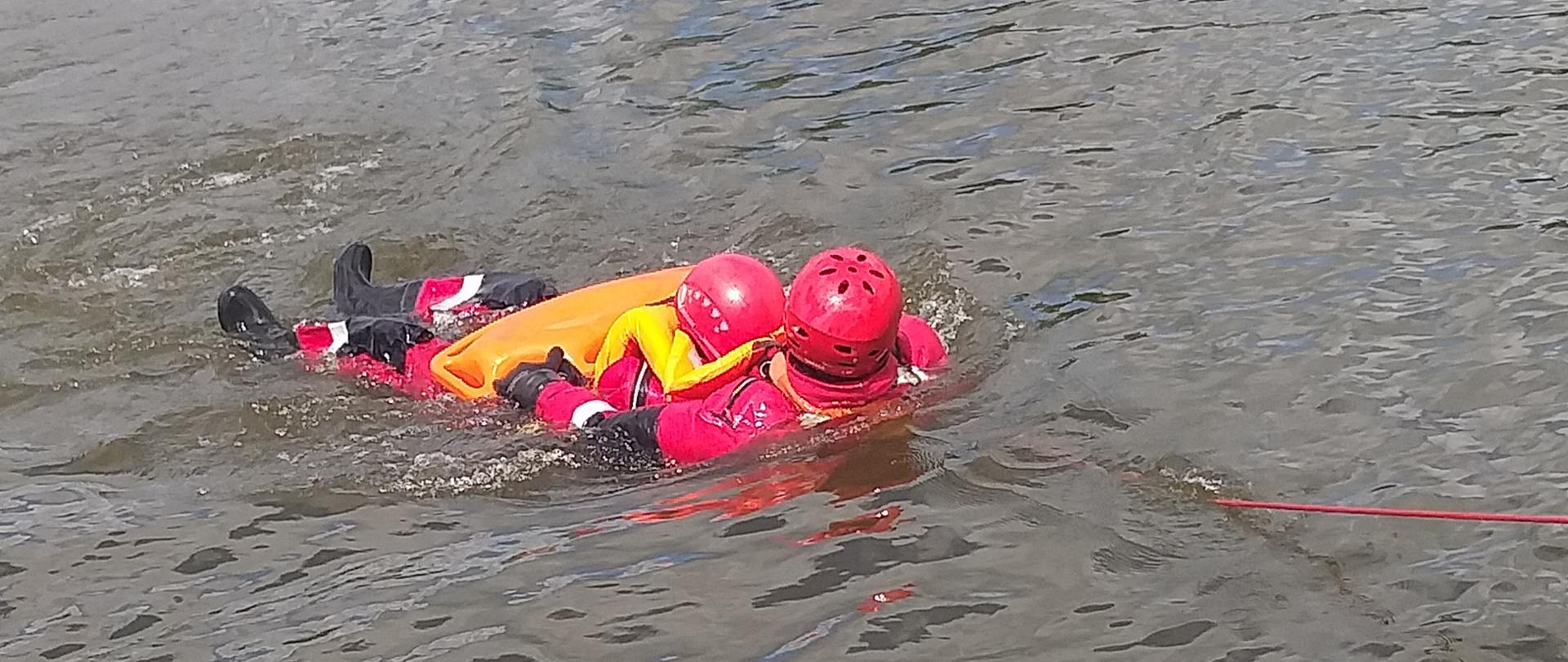 strażak holowany do brzegu z drugim strażakiem