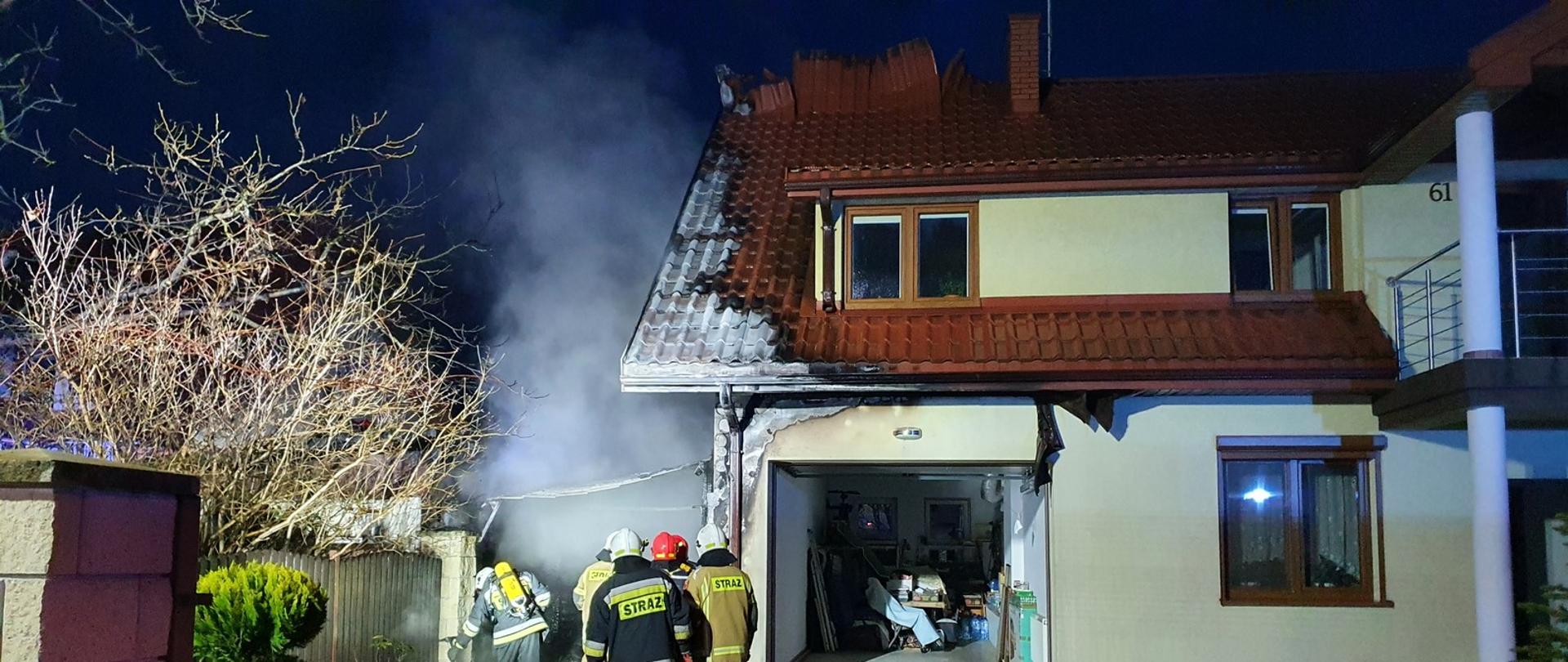 strażacy dogaszają pożar zabudowań gospodarczych