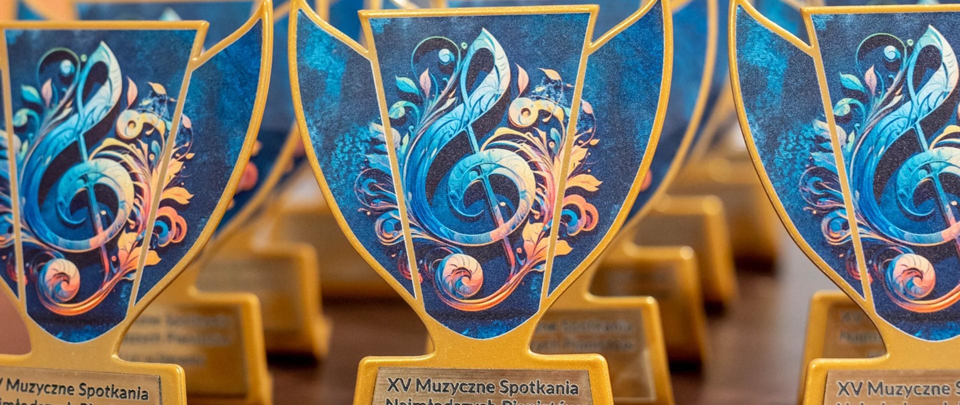 Statuetki konkursu w kolorach chabrowym (niebieskim) i złotym z kluczem wiolinowym. 