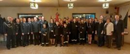 druhowie osp Rąbień i kilku strażaków pozują do zdjęcia grupowego w czasie zebrania