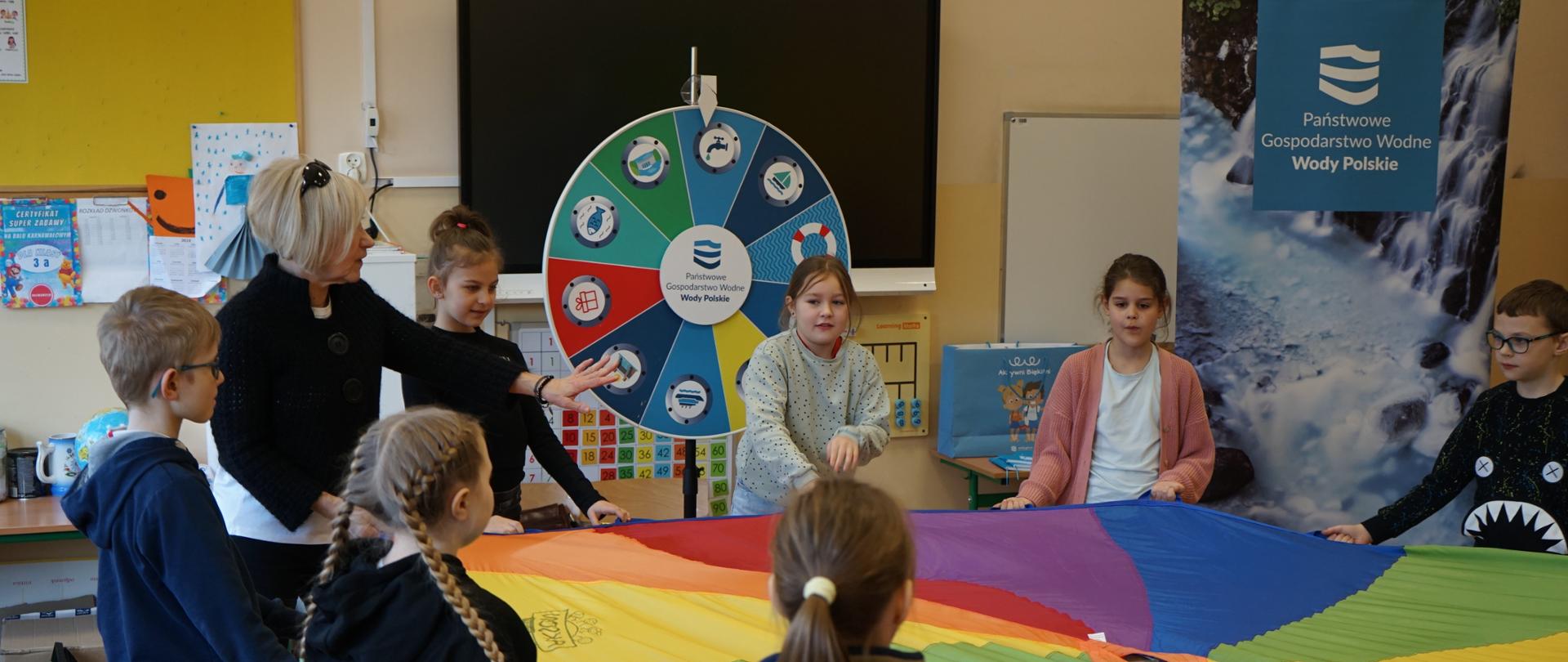 Dzieci bawią się chusta animacyjną podczas zajęć w szkole SP nr 7 w Rumi