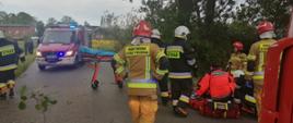 Widoczne miejsce zdarzenia uszkodzony pojazd oraz służby działające na miejscu- straż pożarna, Pogotowie Ratunkowe, Policja