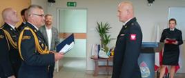 a zdjęciu mł. kpt. Marcin Czarnecki odbiera z rąk Kujawsko-Pomorskiego Komendanta Wojewódzkiego PSP nadbrygadiera Jacka Kaczmarka akt powołania na stanowisko Zastępcy Komendanta Powiatowego PSP w Rypinie