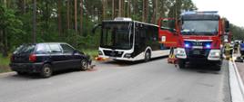 Samochód osobowy po zderzeniu z autobusem, z lewej strony pojazd strażacki