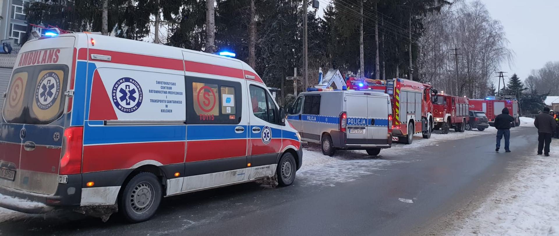 Samochody straży pożarnej oraz zespół ratownictwa medycznego. Wokół śnieg.
