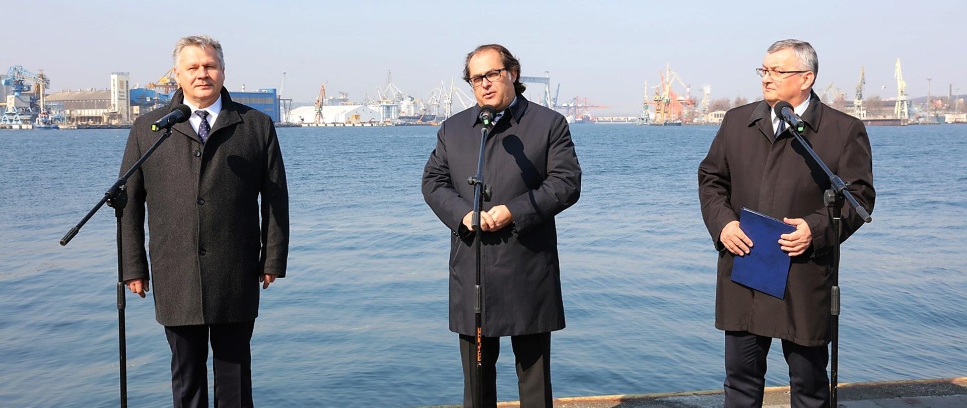 Minister marek Gróbarczyk, Minister Andrzej Adamczyk oraz Prezes Zarządu Morskiego Portu Gdynia Adam Meller podczas briefingu na tle portu