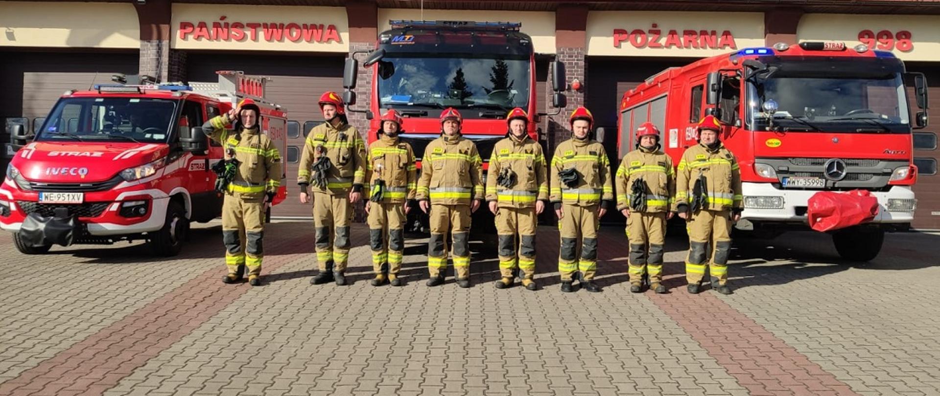 Strażacy na tle wozów strażackich oraz strażnicy oddają hołd ofiarom katastrofy Smoleńskiej