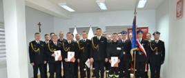 zdjęcie grupowe strażaków w mundurach galowych z prawej strony poczet sztandarowy ze sztandarem KP PSP w Ropczycach