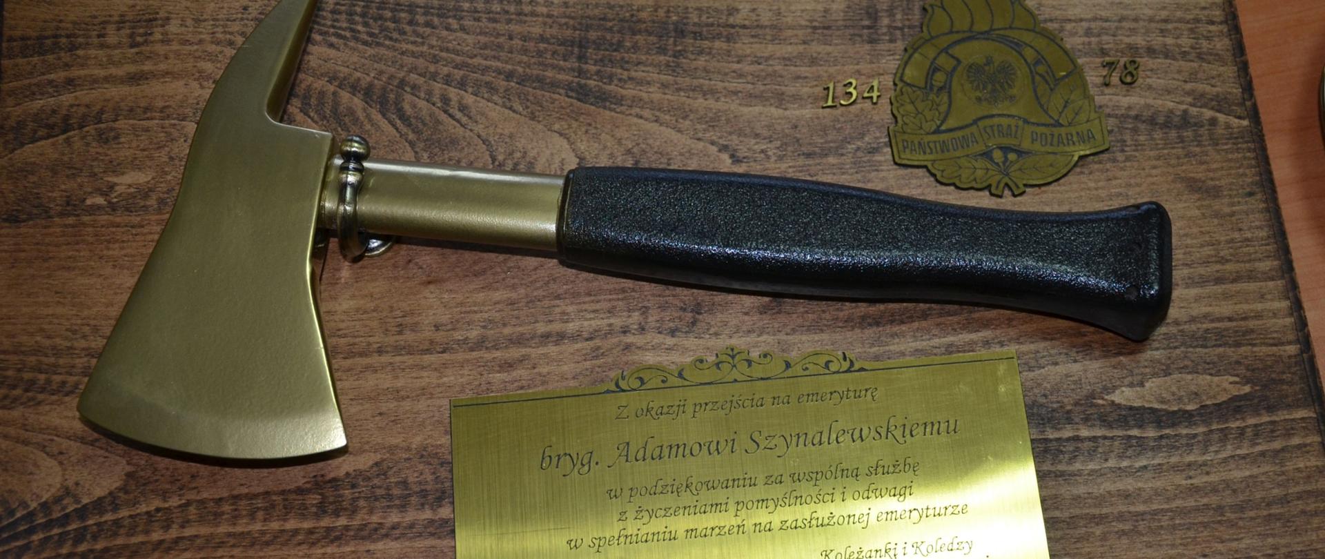 foto przedstawia pamiątkę w formie toporka strażackiego z grawerką