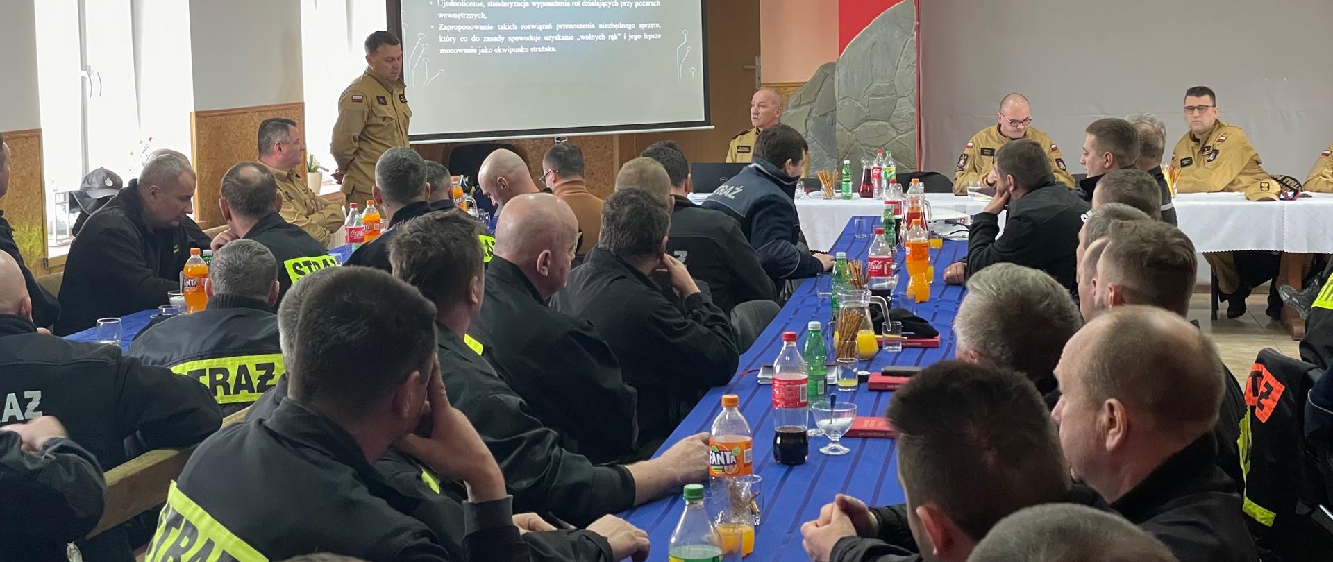 Prowadzący oraz uczestnicy zajęć przy stołach.