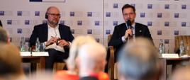 Minister rozwoju i technologii Waldemar Buda oraz wicepremier i minister gospodarki Republiki Słowackiej Richard Sulik na obradach Polsko-Słowackiego Forum Biznesu, minister Buda przemawia przez mikrofon, po jego lewej stronie siedzi wicepremier Sulik
