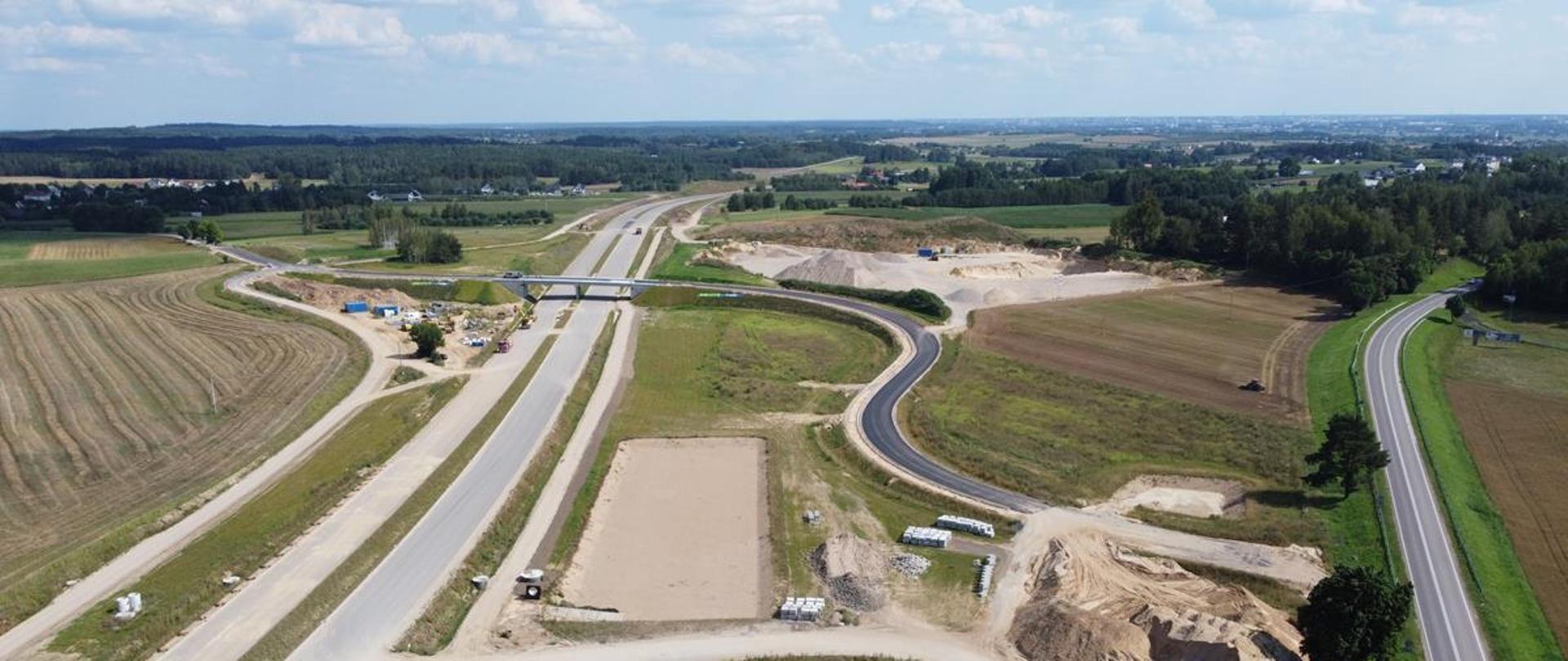 Widok z lotu ptaka - droga powiatowa przechodzi wiaduktem nad budowaną , dwujezdniową "eską"