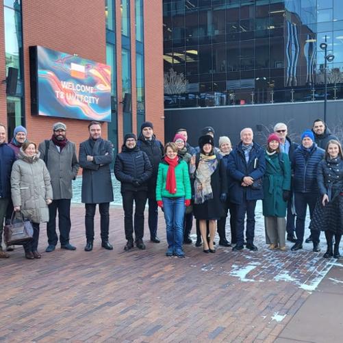 Grupa przedstawicieli sześciu pracowni architektonicznych w Kijowie pozuje na tle budynku