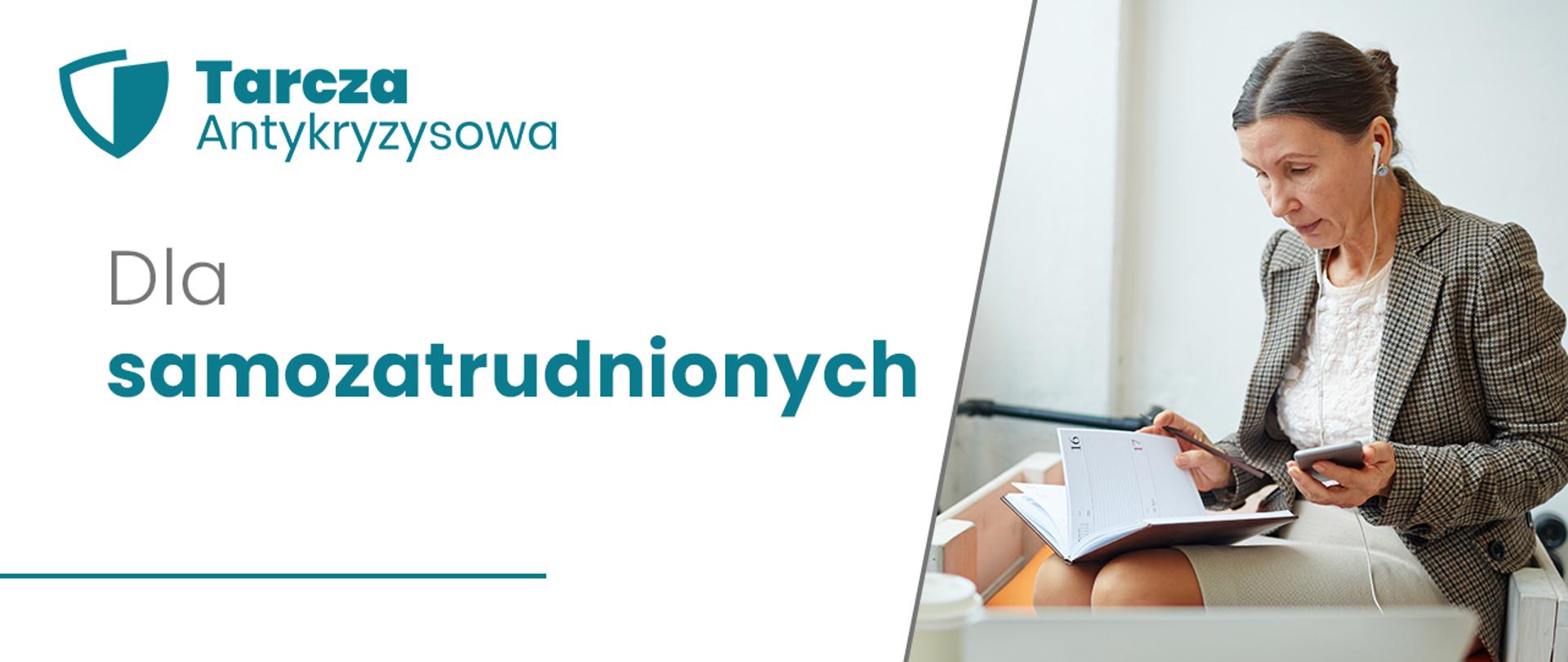Grafika: po lewej stronie napis na białym tle: Dla samozatrudnionych. Nad napisem w lewym górnym rogu turkusowy napis Tarcza Antykryzysowa i logo tarczy. Po prawej stronie zdjęcie, na którym widoczna jest kobieta ubrana w białą bluzkę, marynarkę w kratę i jasną spódnicę. Ma spięte włosy i białe słuchawki podłączone do telefonu. Siedzi na krześle. W dłoni trzyma telefon. Na kolanach otwarty kalendarz książkowy, w prawej ręce trzyma długopis. 