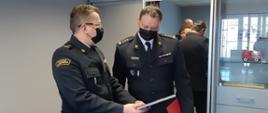 Zdjęcie przedstawia Zastępcę Komendanta Wojewódzkiego PSP st. bryg. mgr inż. Roberta Tadeusza Dzierżek wręczającego okolicznościowy upominek st. bryg dr inż. Tomaszowi Gierasimiukowi,