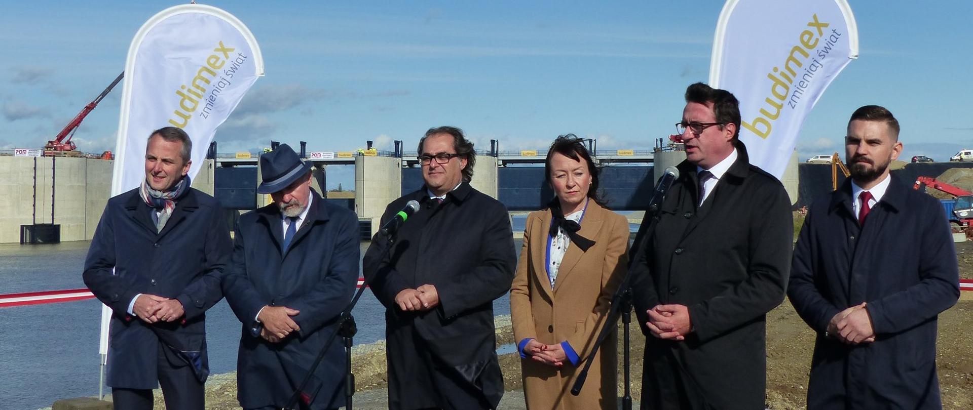 Minister Marek Gróbarczyk na tle zbiornika Racibórz Dolny. Przemawia Przemysław Daca - prezes Wód Polskich