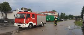 Na zdjęciu widać strażaków działających podczas podtopień oraz wóz strażacki