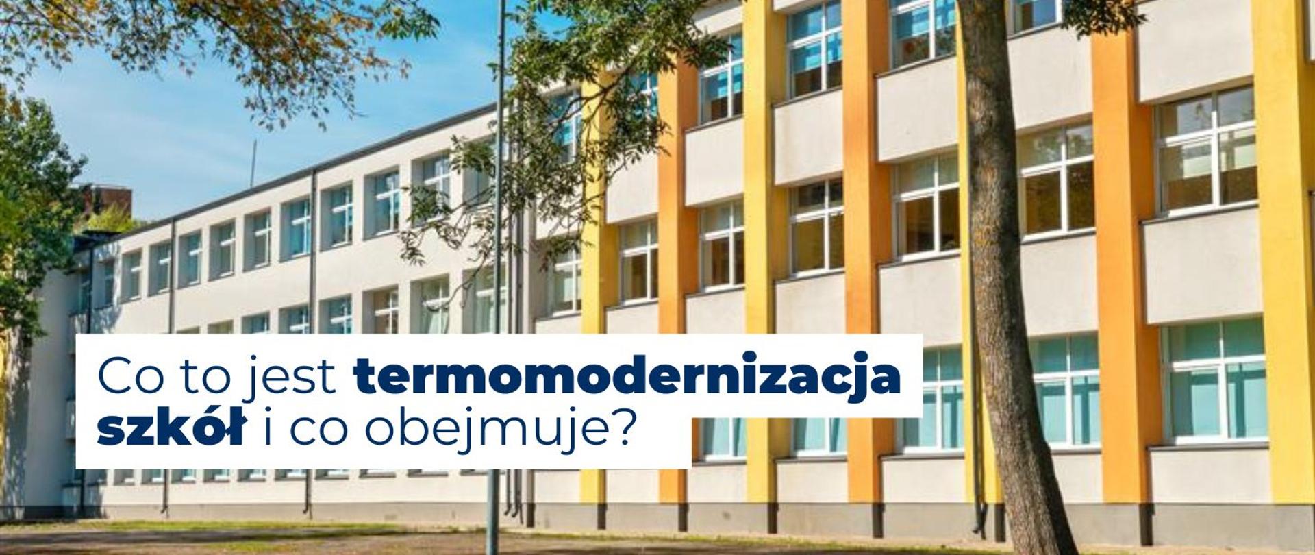 na zdjęciu widoczna jest szkoła wśród zielonych drzew. Na środku widnieje napis Co to jest termomodernizacja szkół i co obejmuje?
