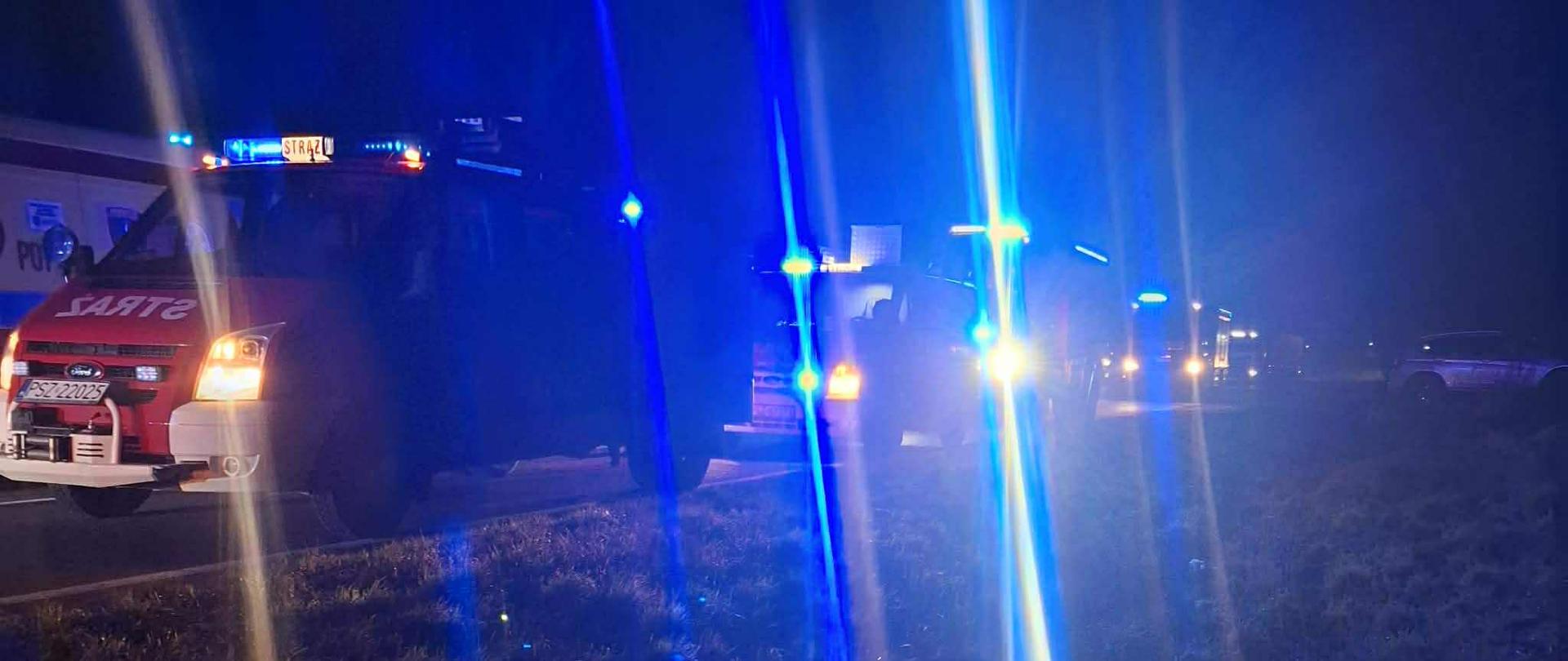 Samochody strażackie na drodze, ciemno