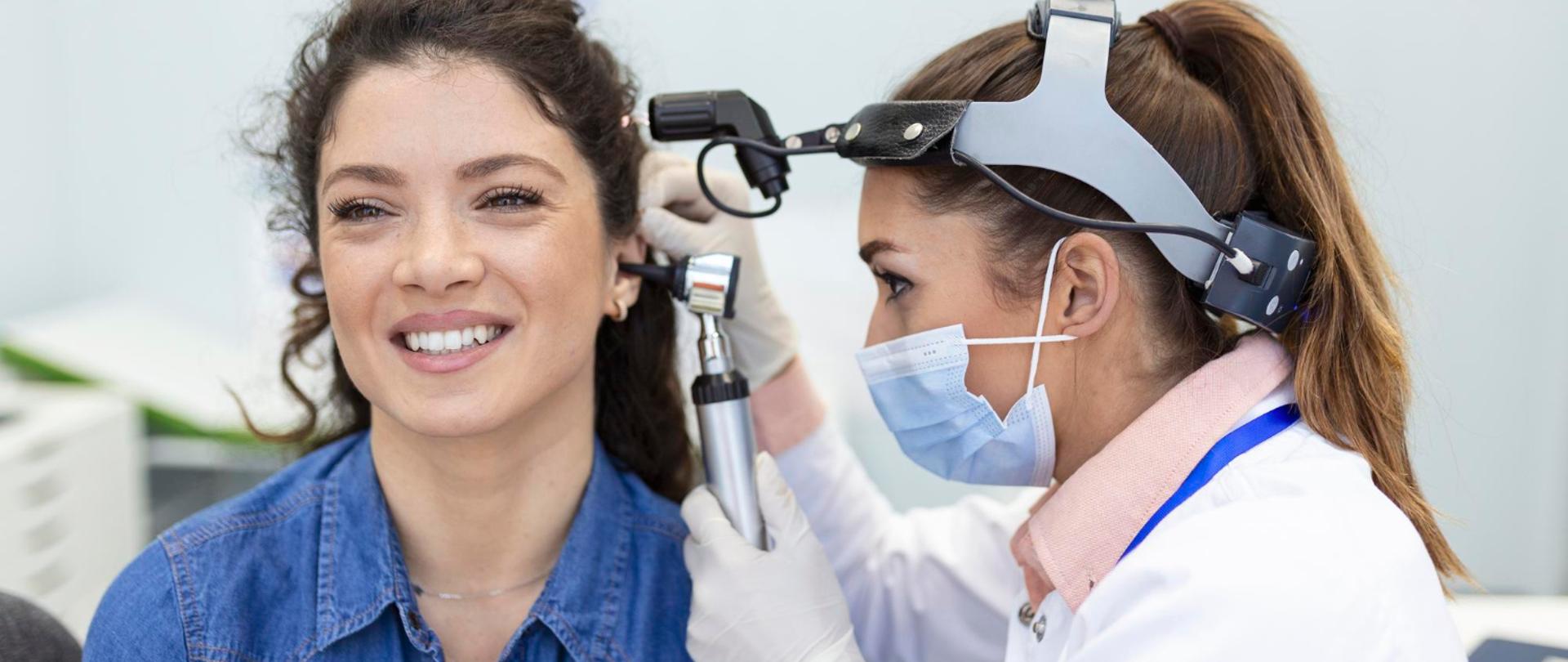 Lekarka laryngolog wykonuje badania słuchu dla pacjentki za pomocą otoskopu.