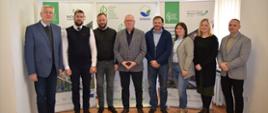 Grupa sześciu mężczyzn i dwóch kobiet pozuje do zdjęcia. Za ich plecami banery z logo w kształcie zielonego liścia i napis Regionalna Dyrekcja Ochrony Środowiska w Gorzowie Wielkopolskim.
